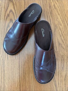 Clarks slip-on mule clogs featuring a buckle detail